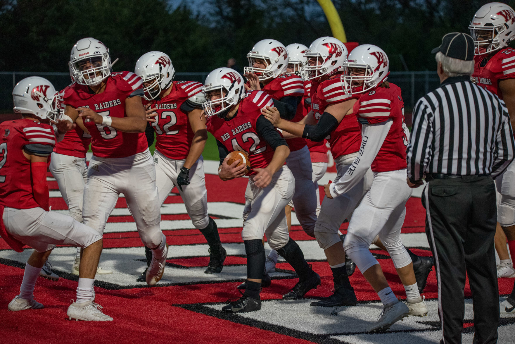 Taylor Beck, middle, is surrounded by his teammates in the end zone after returning a fumble for a touchdown on the opening kickoff against Marysville on Friday, October 4, 2019.